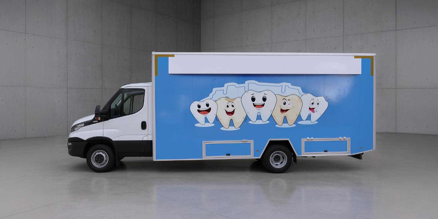 A white and blue van with a cartoon tooth design, parked in a gray room with a shiny floor.